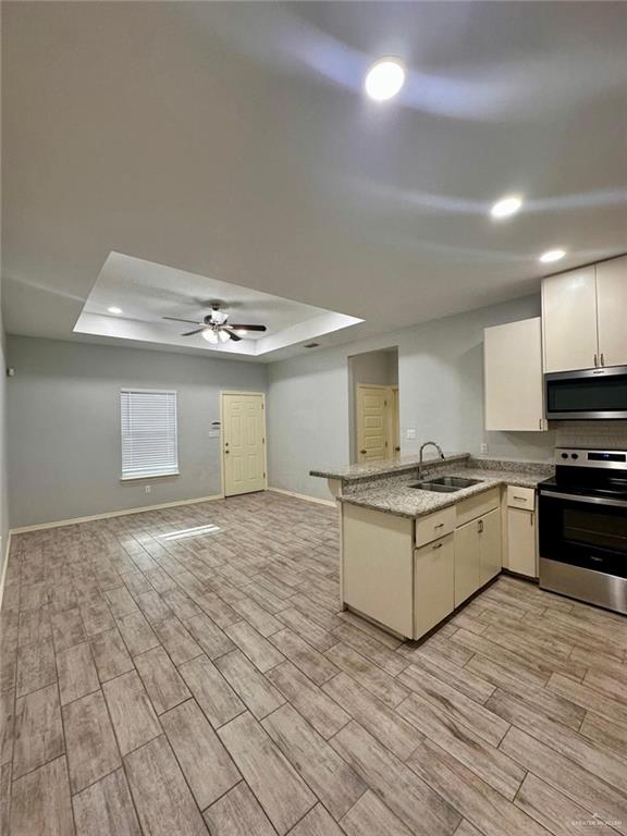 1503 West Heritage Drive, Unit 1 Pharr, TX 78577 - Photo 6 of 17 Kitchen with a tray ceiling, stainless steel appliances, a peninsula, wood tiled floors, and recessed lighting