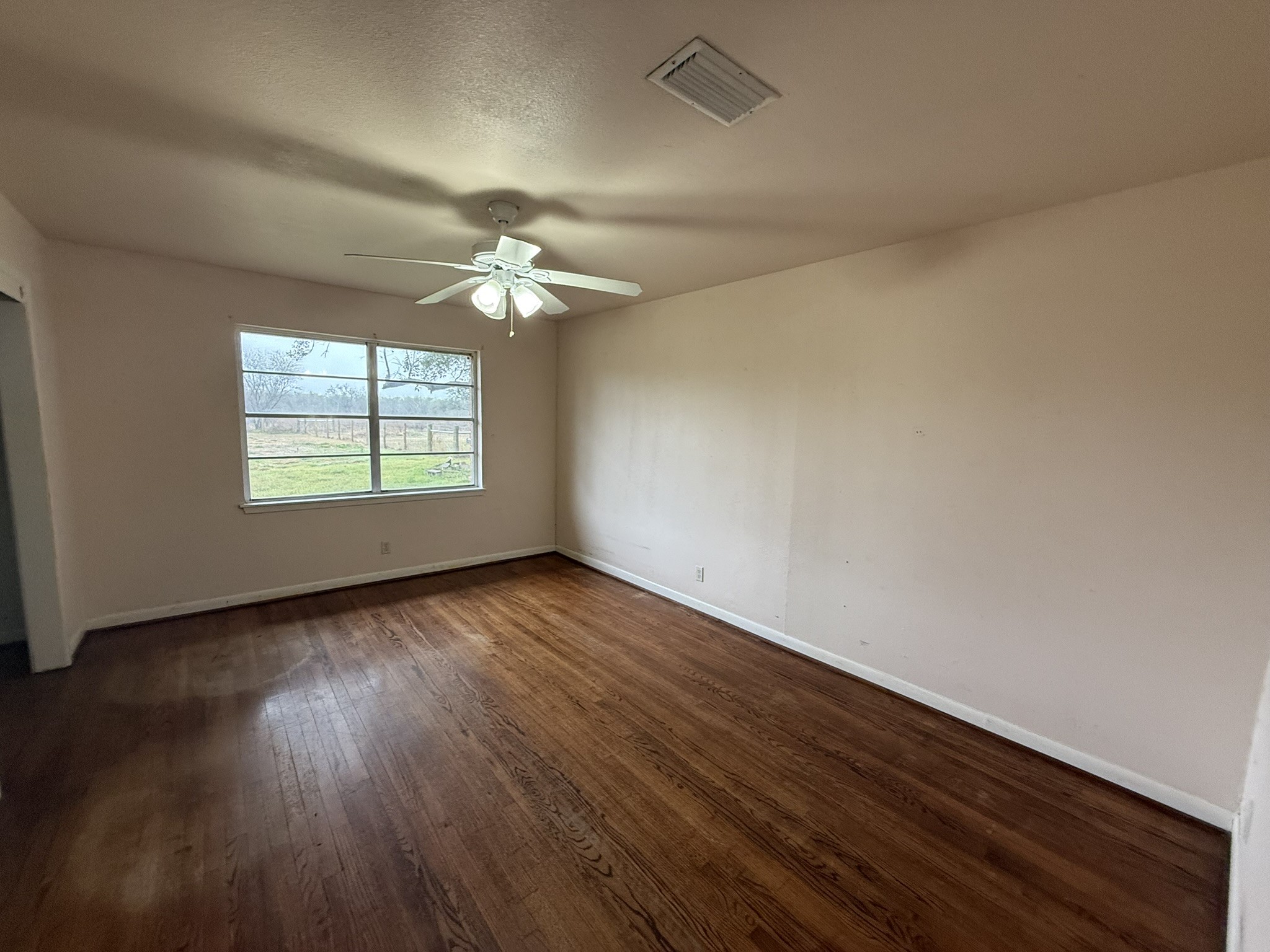 13907 Mueck Road Needville, TX 77461 - Photo 15 of 27 an empty room with wooden floor and windows