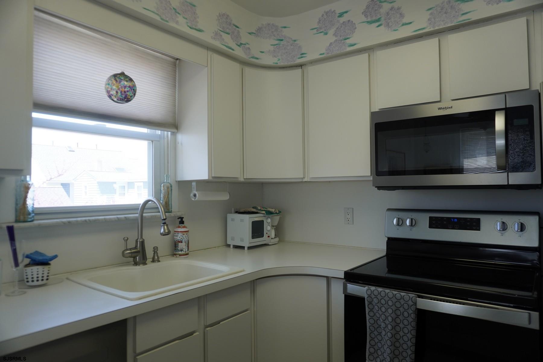 15 South Decatur Avenue, Unit B Margate City, NJ 08402 - Photo 14 of 27 a kitchen with a sink a microwave a stove and cabinets