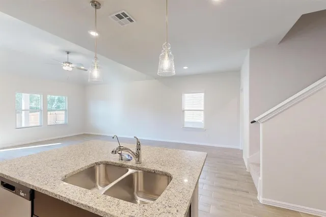 a kitchen that has a sink a window and chairs