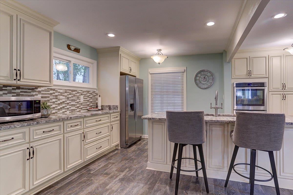 1611 Ivy Road Memphis, TN 38117 - Photo 9 of 29 a kitchen with stainless steel appliances granite countertop a stove a refrigerator a microwave a dining table and chairs