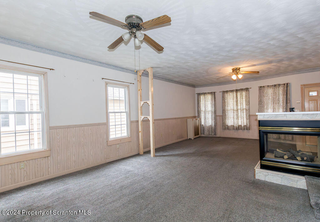 1148 West Locust Street Scranton, PA 18504 - Photo 12 of 40 a view of livingroom and kitchen with fireplace ceiling fan and windows