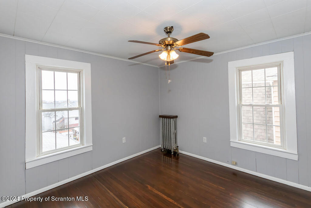 1148 West Locust Street Scranton, PA 18504 - Photo 27 of 40 an empty room with wooden floor fan and windows