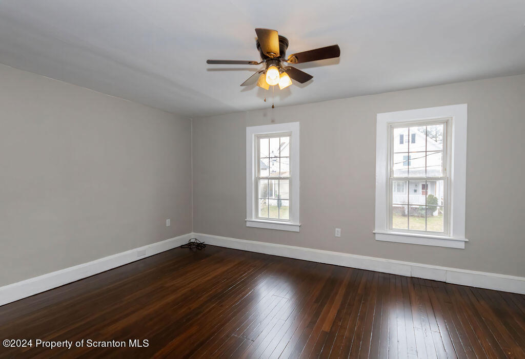 1148 West Locust Street Scranton, PA 18504 - Photo 31 of 40 a view of an empty room with wooden floor and a window