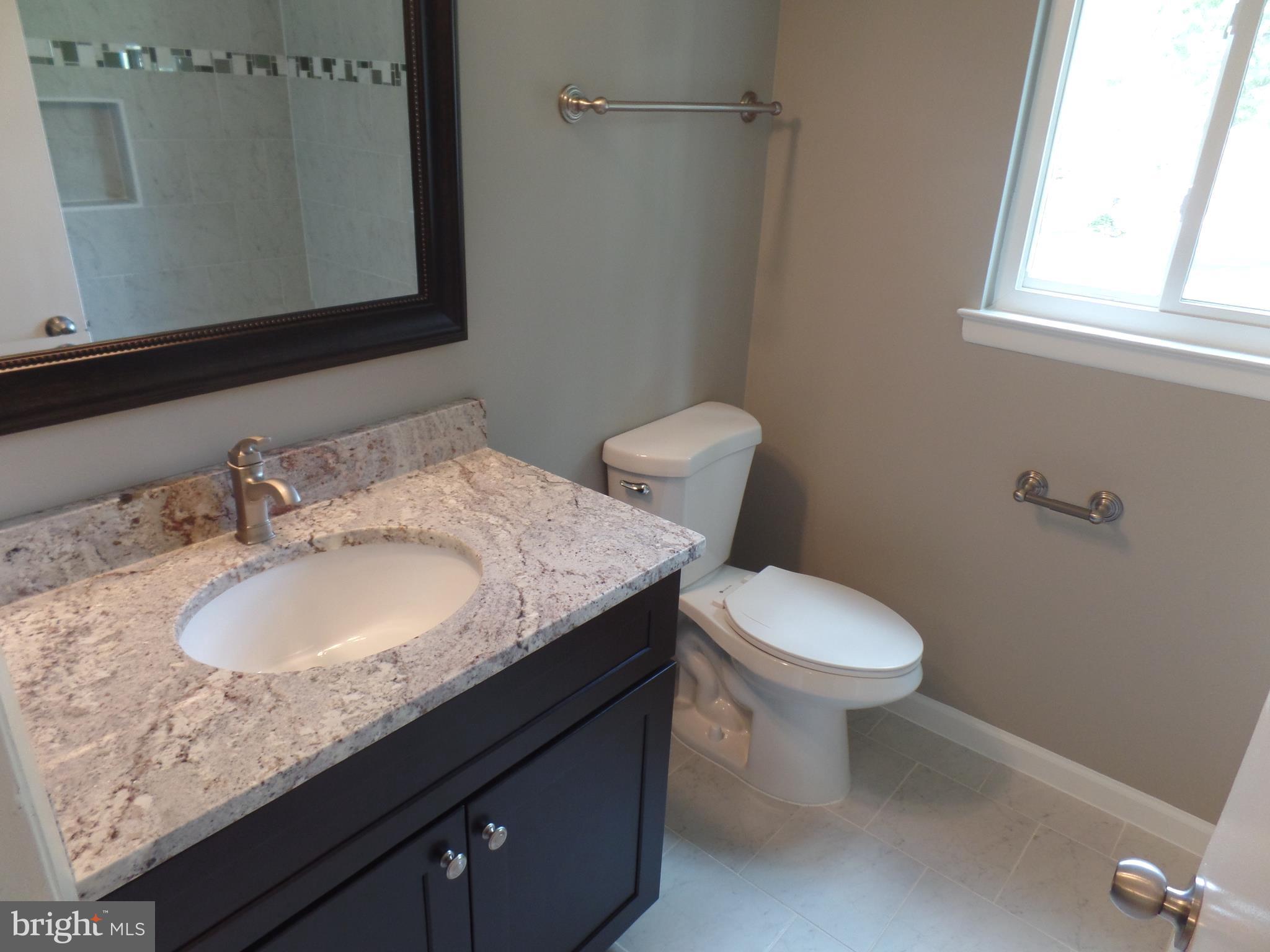 18940 Glendower Road Gaithersburg, MD 20879 - Photo 20 of 30 a bathroom with a granite countertop sink toilet and a mirror
