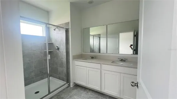 a bathroom with a shower sink and mirror