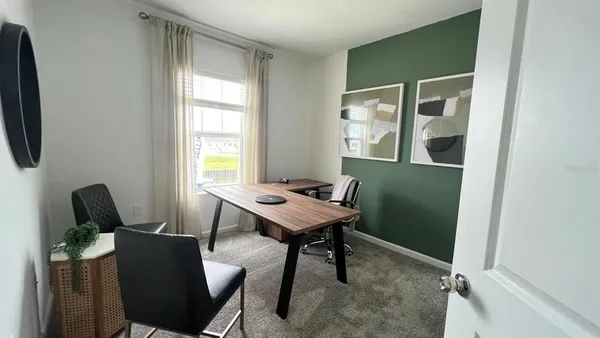 a view of a workspace with furniture and a window