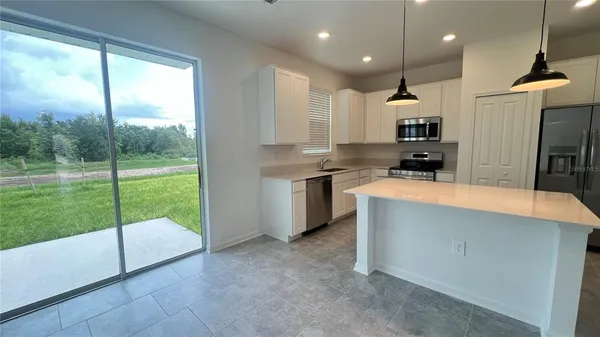 a kitchen with kitchen island a counter top a sink stainless steel appliances and cabinets