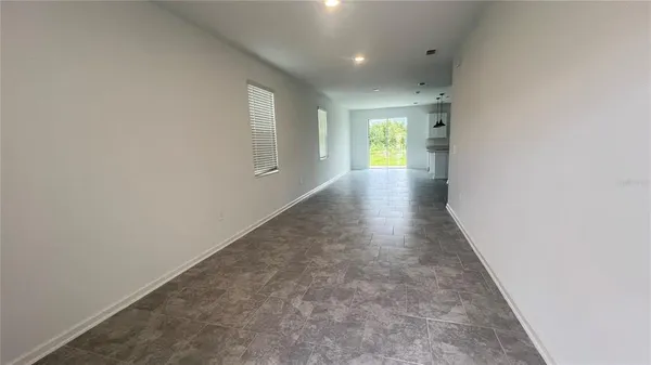 a view of hallway with wooden floor and a window