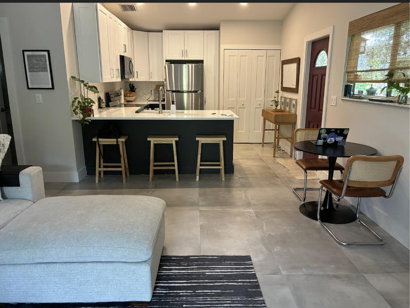 1822 Windsor Drive, Unit 1 Juno Ridge, FL 33408 - Photo 9 of 12 a living room with stainless steel appliances furniture a rug and a kitchen view