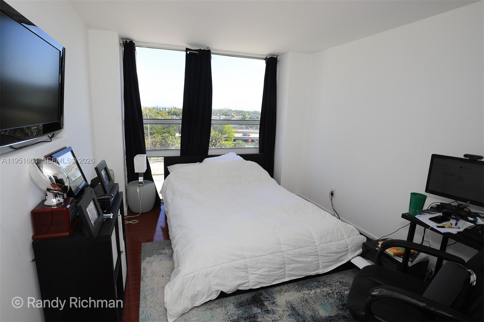 600 Northeast 36th Street, Unit 514 Miami, FL 33137 - Photo 17 of 27 a bed room with a bed television and a large window
