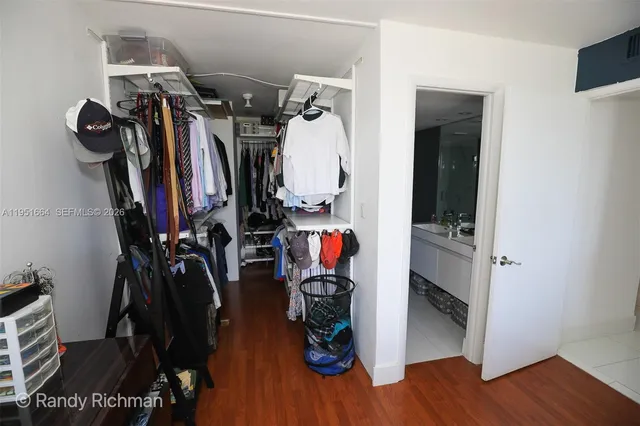 a view of walk in closet with clothes and shoes