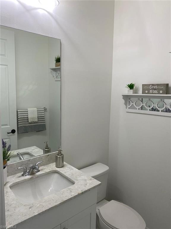 8984 Madrid Circle Naples, FL 34104 - Photo 12 of 15 a bathroom with a sink toilet and mirror