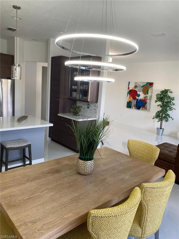 8984 Madrid Circle Naples, FL 34104 - Photo 3 of 15 a dining room with furniture and a chandelier