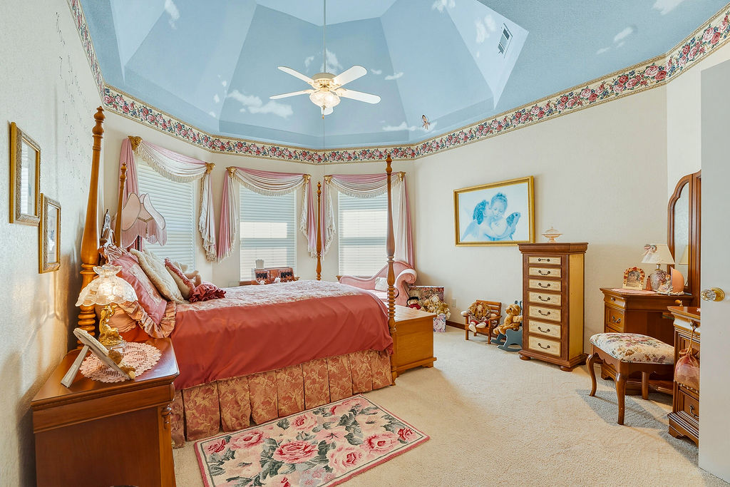1009 Southeast County Road Ada, OK 74820 - Photo 37 of 92 Recessed polygonal ceiling with decorative painting, ceiling fan with integrated lighting, multiple windows with blinds, and carpeted flooring