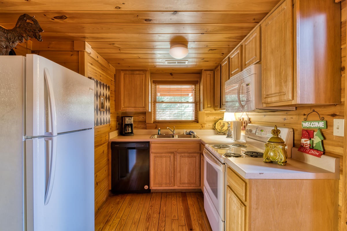 3124 Smoky Ridge Way Sevierville, TN 37862 - Photo 9 of 14 a kitchen with a sink a refrigerator and wooden cabinets