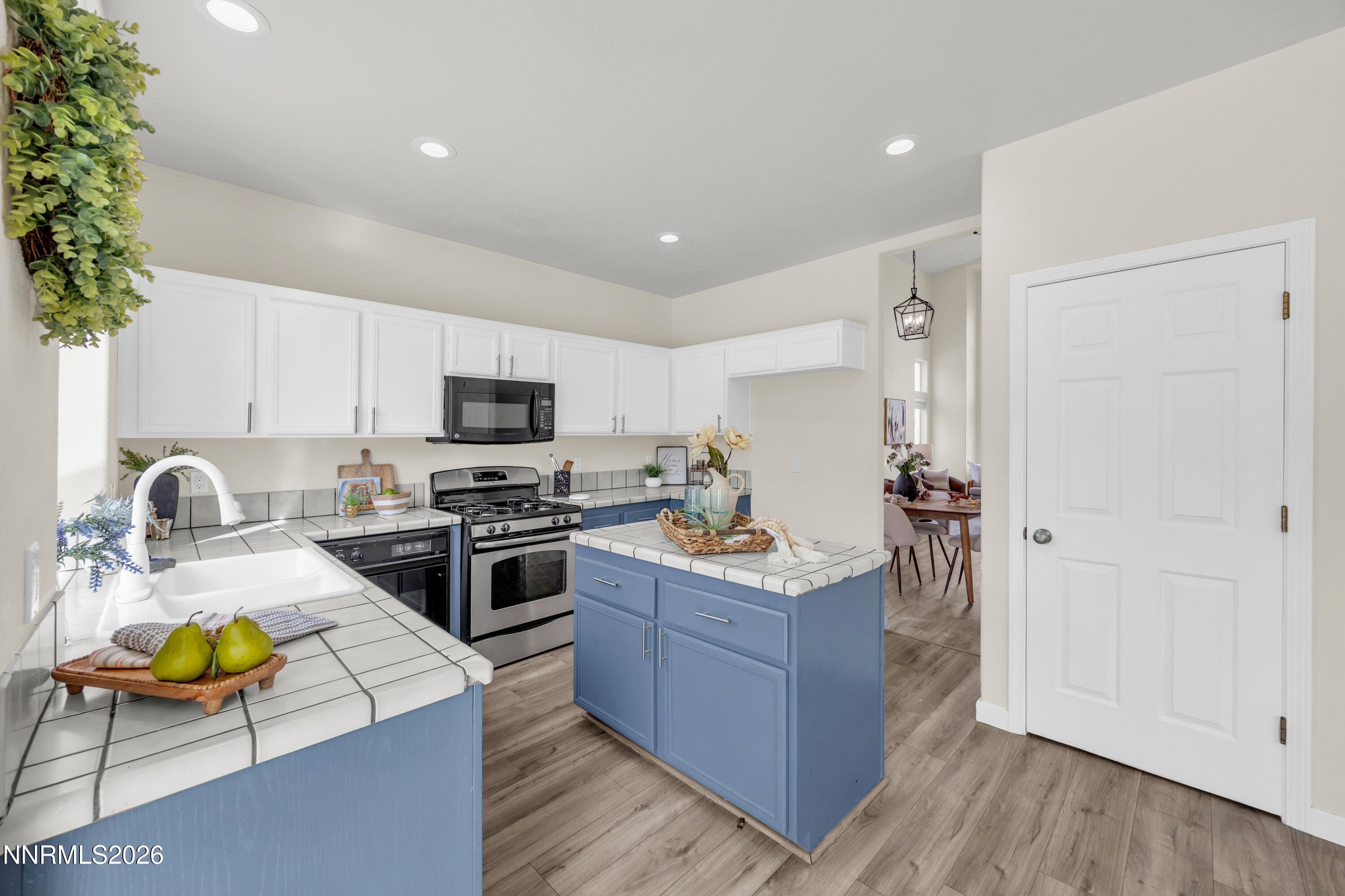 5420 Brittania Drive Reno, NV 89523 - Photo 11 of 25 a kitchen with stainless steel appliances granite countertop a refrigerator a stove top oven a sink dishwasher and white cabinets with wooden floor