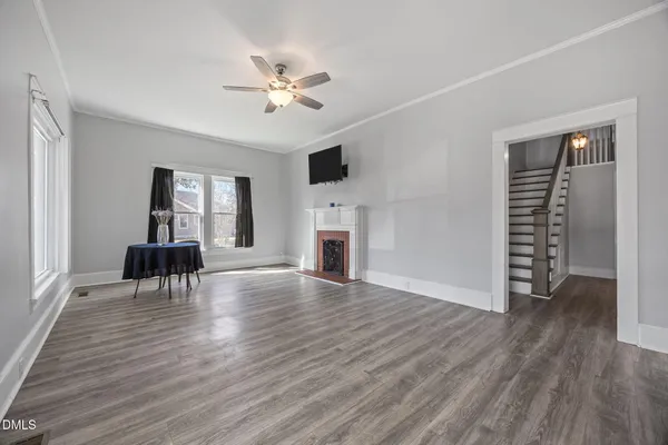 a view of empty room with wooden floor and fan