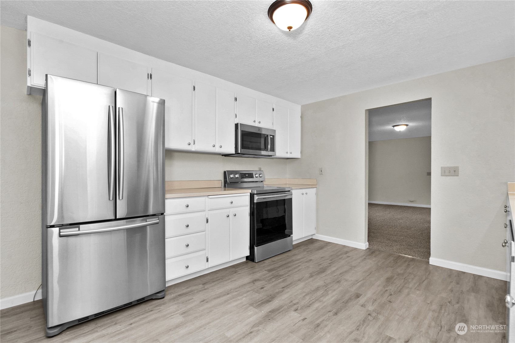 151 Ramsey Road Chehalis, WA 98532 - Photo 3 of 25 a kitchen with stainless steel appliances white cabinets and wooden floors