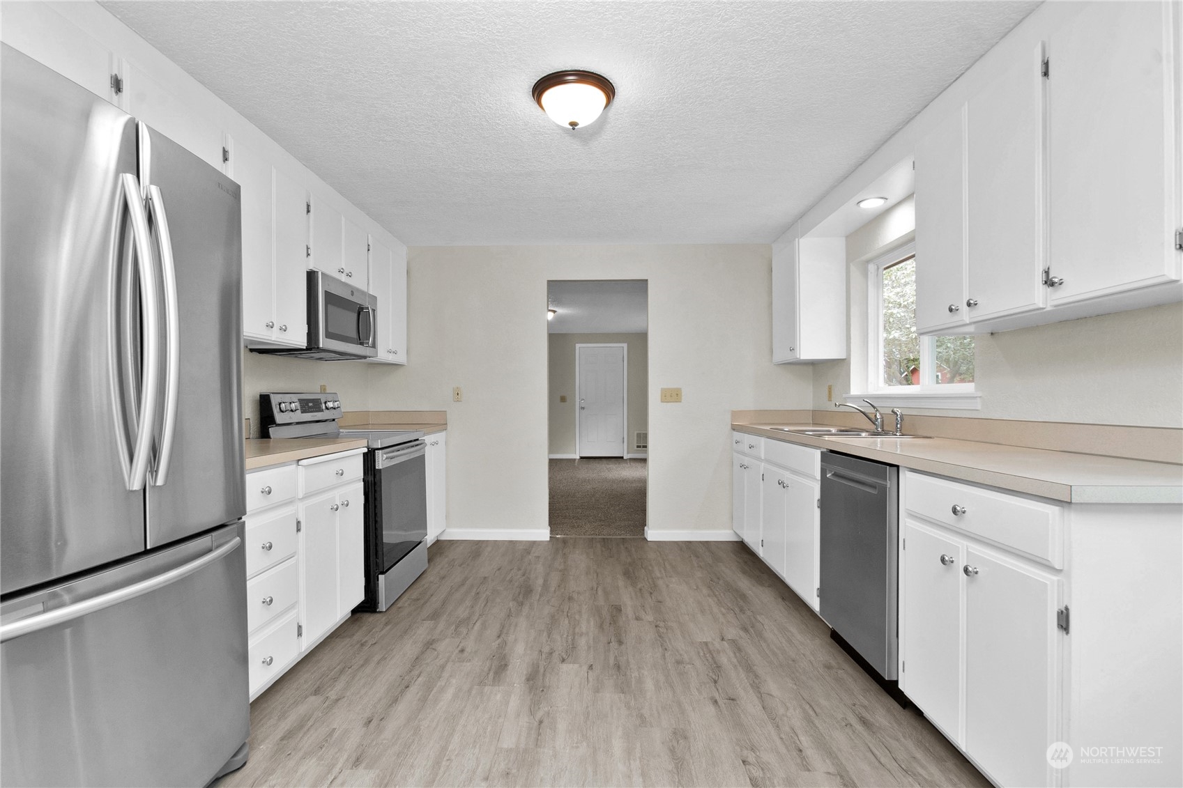 151 Ramsey Road Chehalis, WA 98532 - Photo 4 of 25 a kitchen with white cabinets and stainless steel appliances