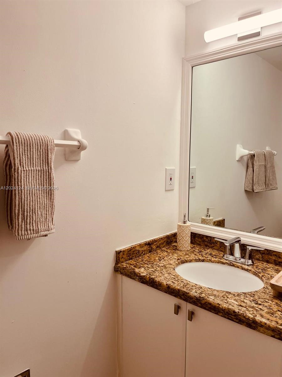 120 South Douglas Road, Unit 302 Miami, FL 33134 - Photo 12 of 28 a bathroom with a granite countertop sink and a mirror