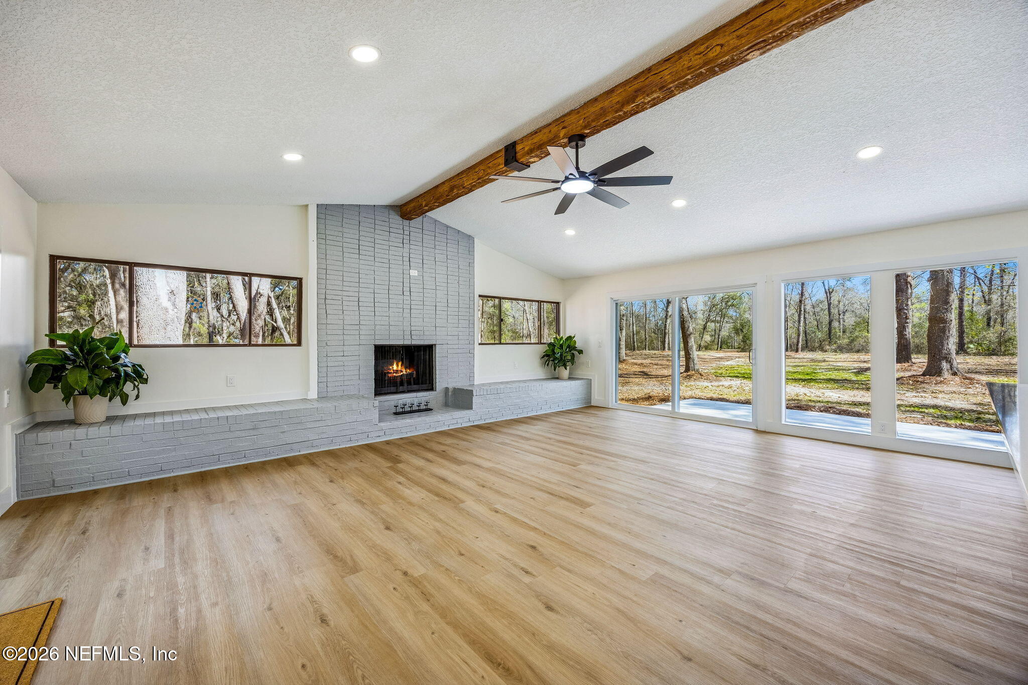 16684 Oak Hill Road Hilliard, FL 32046 - Photo 3 of 33 a view of empty room with wooden floor and fireplace