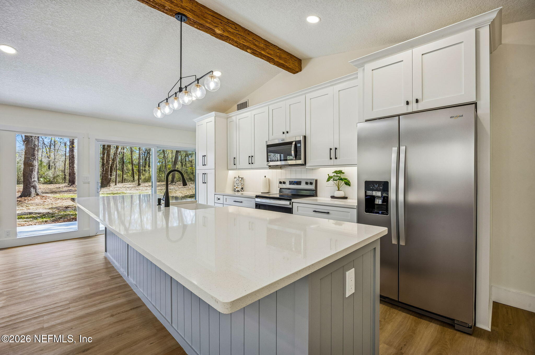 16684 Oak Hill Road Hilliard, FL 32046 - Photo 9 of 33 a large kitchen with kitchen island a large counter top and stainless steel appliances