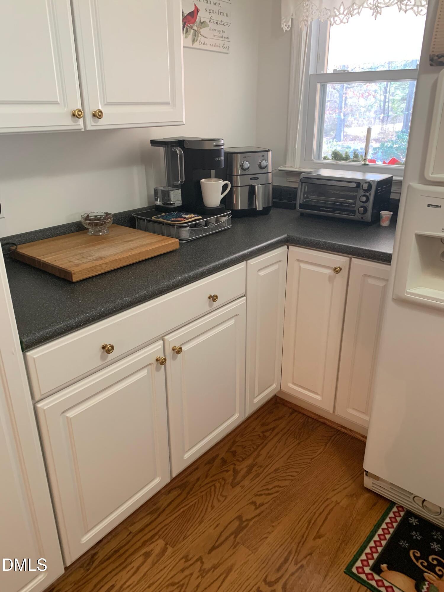 133 Sam Horton Road Louisburg, NC 27549 - Photo 6 of 15 a kitchen with granite countertop white cabinets and white appliances