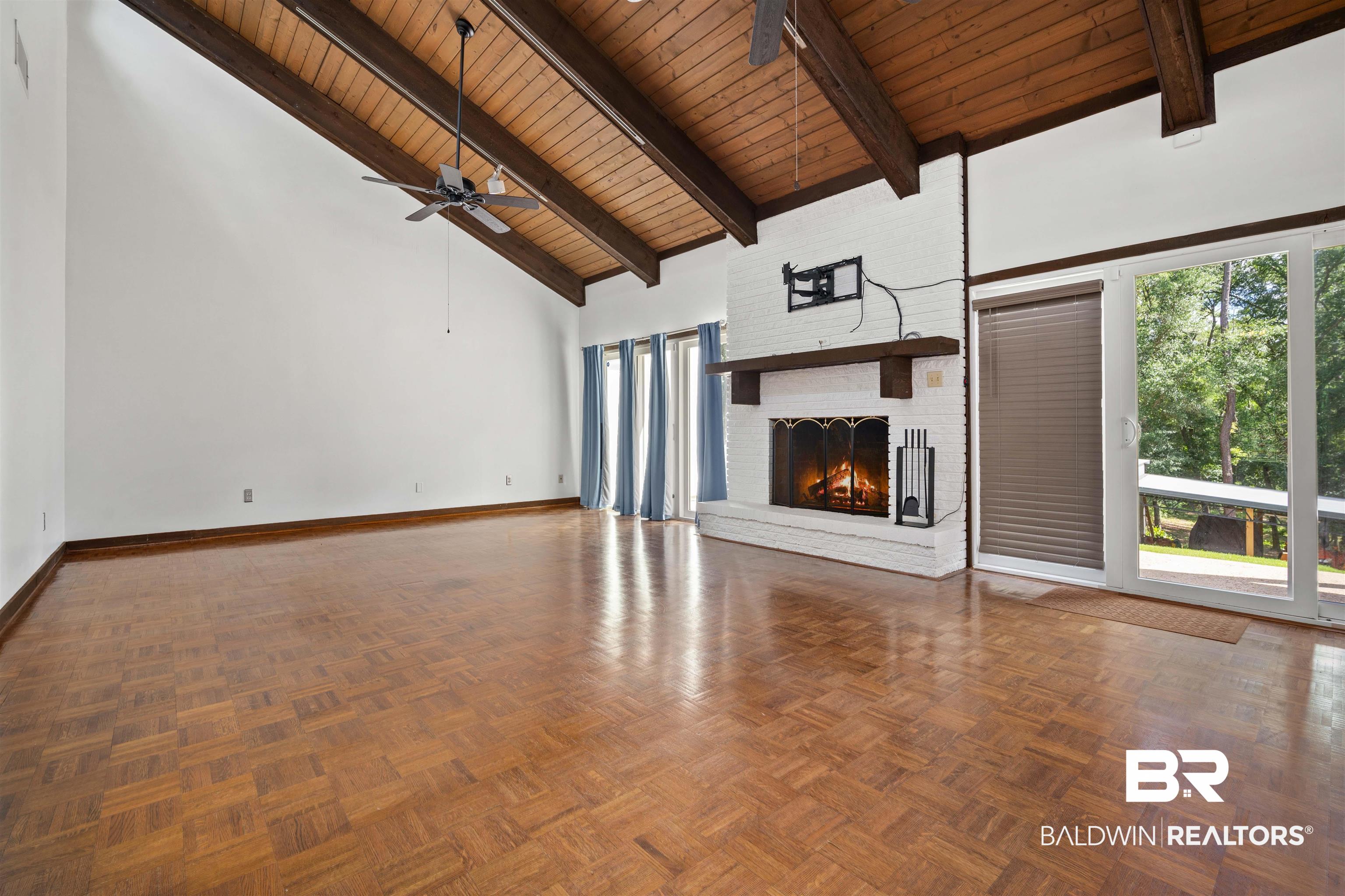 7912 Yorkhaven Road Mobile, AL 36695 - Photo 5 of 41 Unfurnished living room featuring high vaulted ceiling, a fireplace, plenty of natural light, a wood ceiling with exposed beams, and a ceiling fan