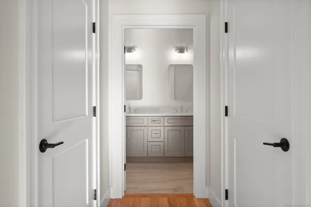 a bathroom with a double vanity sink toilet and mirror
