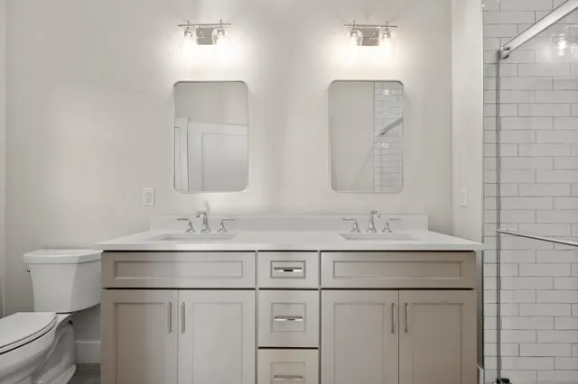 a bathroom with a sink shower and a mirror