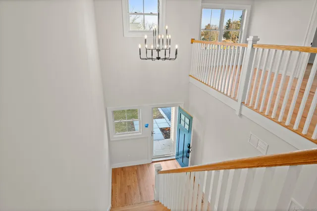 a view of a hallway with wooden floor and staircase