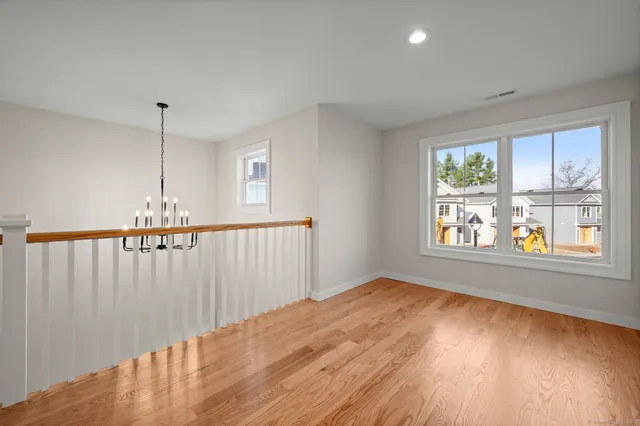 an empty room with wooden floor and window