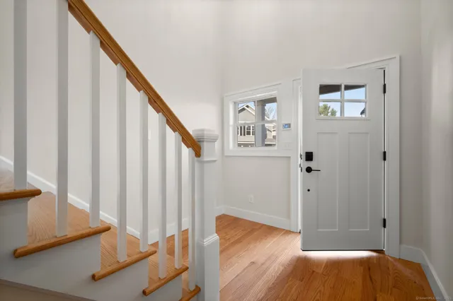 a view of staircase with wooden floor and white walls