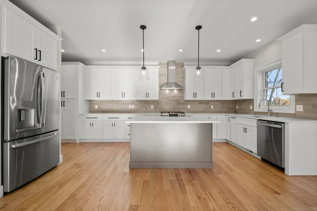 a kitchen with granite countertop white cabinets and white appliances