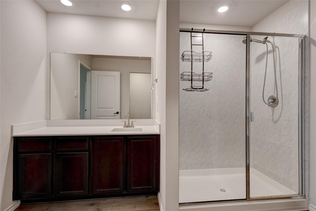 1016 Rio Bravo Drive Forney, TX 75126 - Photo 13 of 25 Bathroom featuring a dark wood-finish vanity with a light-colored countertop, an undermount sink, and a large wall-mounted mirror
