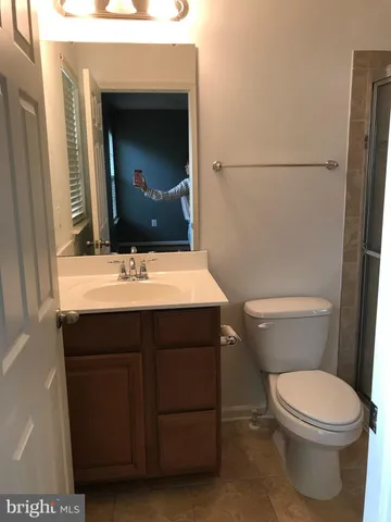 a bathroom with a sink vanity mirror and toilet