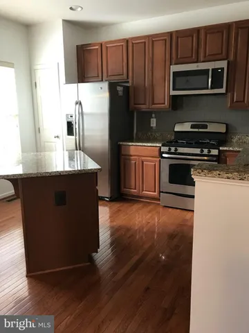 a kitchen with stainless steel appliances wooden cabinets a stove top oven a sink and dishwasher