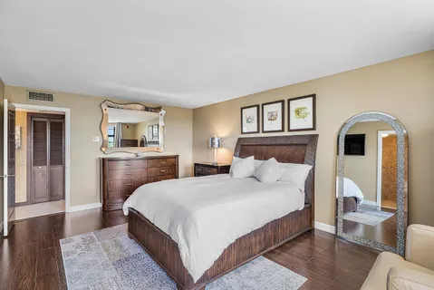 a bedroom with a large bed and a flat tv screen on dresser