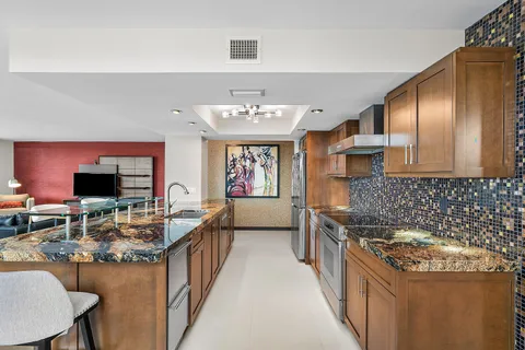 a open kitchen with stainless steel appliances granite countertop a stove and refrigerator