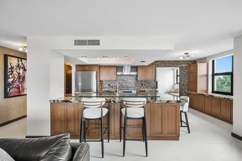 a kitchen with stainless steel appliances granite countertop a stove a sink and a refrigerator