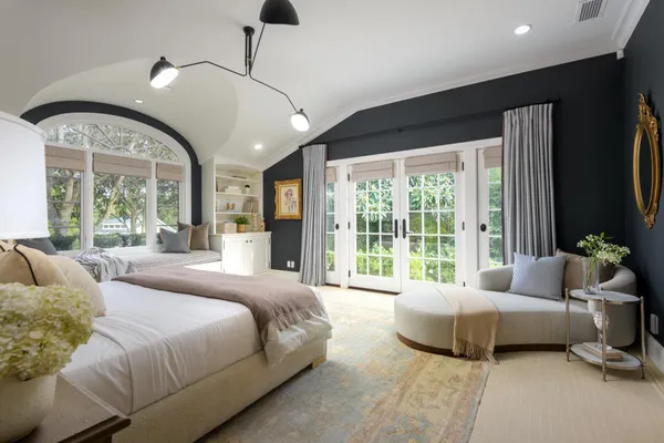 a spacious bedroom with a bed and large windows