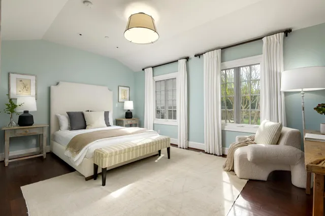 a spacious bedroom with a bed and glass window