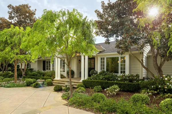 a front view of a house with a garden