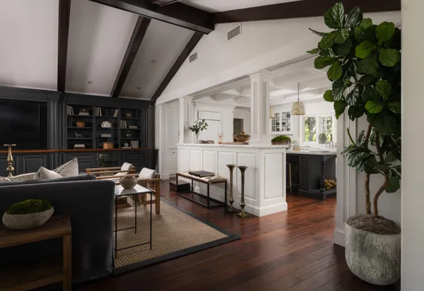 a living room with furniture a potted plant and a wooden floor