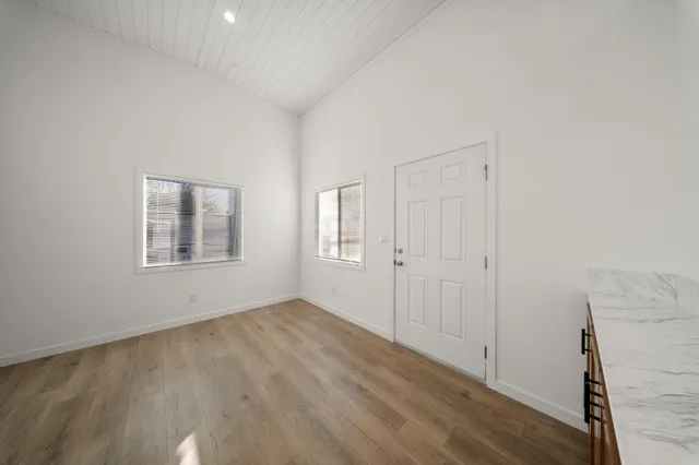 a view of an empty room with windows and closet