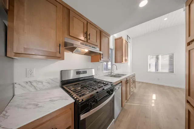 a kitchen with stainless steel appliances granite countertop a stove and a sink