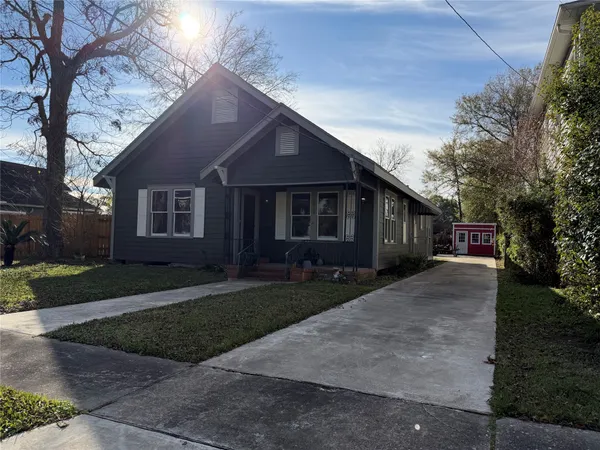 a front view of a house with a yard and trees