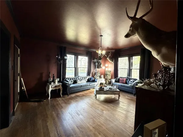 a living room with furniture a chandelier a fireplace and a large window