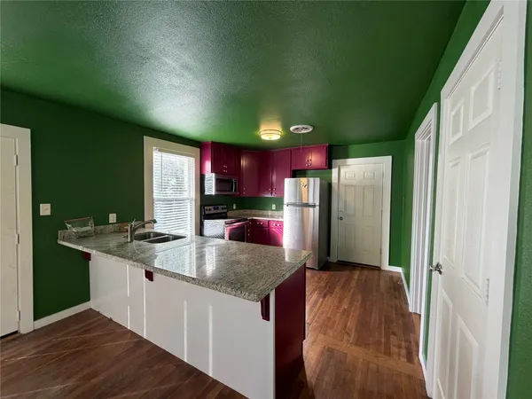 a kitchen with stainless steel appliances granite countertop a refrigerator a sink and a stove